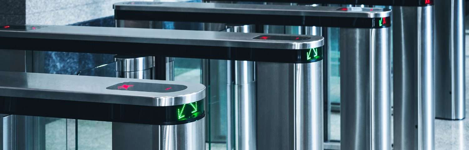 Stainless steel speed-gate turnstiles at a building entrance